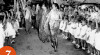 Foto Ibu Fatmawati melambaikan tangan kepada anak-anak yang menyambut kedatangannya pada upacara peletakan batu pertama Gedung Taman Kanak-Kanak 17 Agustus di Kebayoran, 7 Agustus 1953